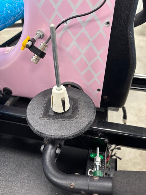 Close-up of a pink scooter with a black handlebar and control panel.
